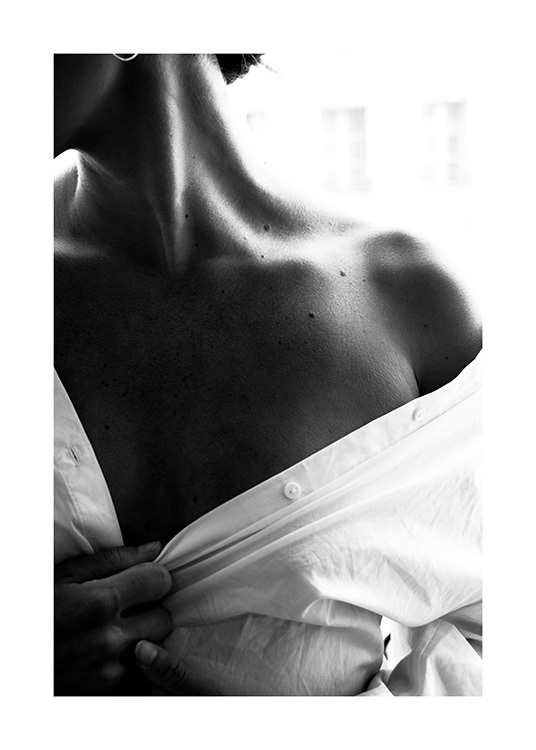  – Black and white photograph of an exposed shoulder of a woman in a white shirt