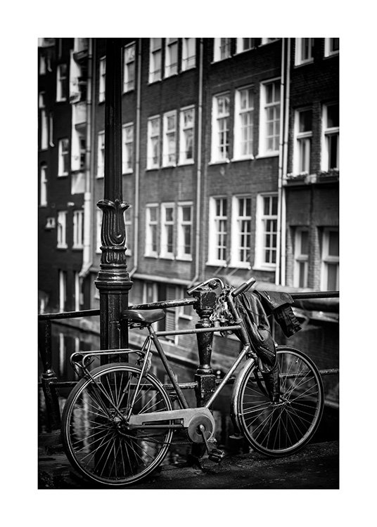  - Black and white photograph of a lamp post next to a parked bike in front of a house with windows