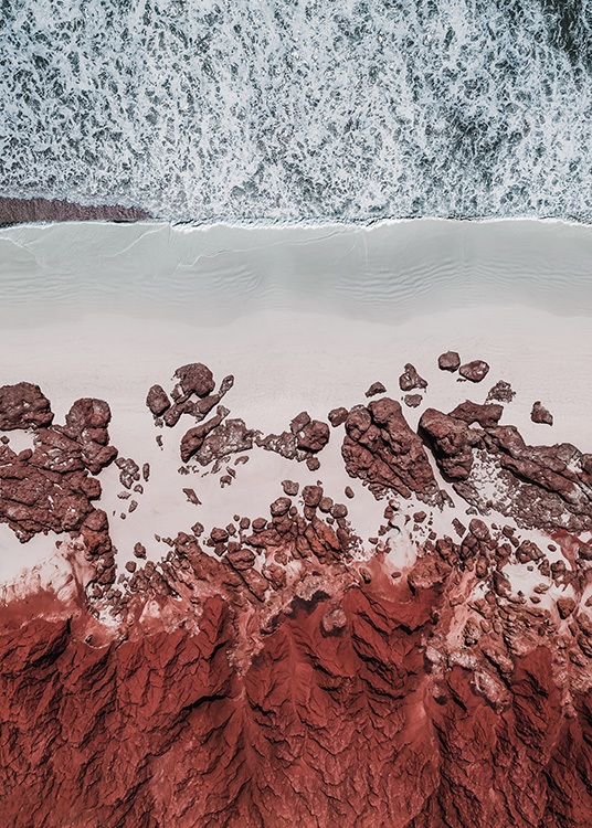  - Photograph with aerial view of a beach with red rocks and red sand