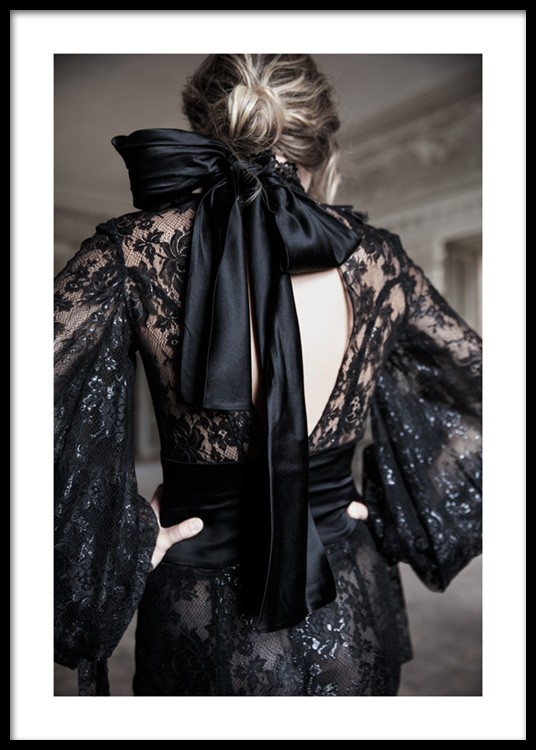  – Photograph of a woman wearing a black dress in lace with a satin bow in black at the neck